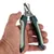 Hand holding a green-black claw scissors with metal blades and spring mechanism, suitable for precise cutting of animal claws.
