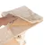 Abnehmbare, beige Plüschauflage mit Klettverschluss auf einer Holzplattform. Hand hebt die Auflage an, darunter sichtbarer Klettstreifen.