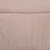 Gros plan sur une surface en tissu beige, texture tricotée visible. Aucun logo ni texte apparent.