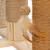 Cat tree with sisal-wrapped posts, wooden base and toy made of woven ball with feathers.