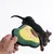 Dog playing with an avocado-shaped fabric toy held by a hand.
