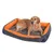 Hund liegt auf einem grauen und orangefarbenen Hundebett mit gepolsterten Rändern.