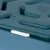Gros plan sur un plateau en plastique bleu avec surface à reliefs et patin antidérapant blanc visible sur le bord.