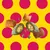 Croquettes de différentes formes et couleurs, dont une croquette verte coupée montrant un intérieur jaune, sur fond à pois rouges et jaunes. Aucun texte ou marque visible.