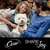 Cesar brand with the phrase 'Share the Joy' shown below a white dog sitting between two people on a sofa.