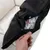 Close-up of a black cover with zip showing filling made of colourful foam pieces. Hand opening the cover.