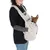 Femme portant un petit chien marron dans un sac de transport gris en tissu polaire, bandoulière réglable et cordon visible. Marque 'goldpaw' partiellement lisible sur le t-shirt.