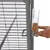 Hand attaches transparent feeder with seeds to grey metal cage. Shows easy assembly of the feeder.
