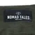 Nomad Tales München. Markenlabel auf grünem Stoff.