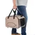Sac de transport beige TIAKI avec poignées noires, côtés en tissu et filet, porté à la main par une personne en jean et t-shirt gris. Aérations visibles sur le côté.