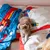 Dog lying on bedding with Superman design. Visible colours: blue, red and white.
