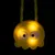 Gelbes LED-Spielzeug in Form eines leuchtenden Gesichts mit grossen Augen, geeignet für dunkle Umgebungen.
