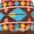 Gros plan sur un tissu en polaire à motif géométrique coloré bleu, orange, jaune et marron. Matière du produit clairement visible.