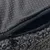 Gros plan sur une housse en tissu gris avec fermeture éclair et surface antidérapante à picots visibles.