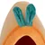 Entrée d’une niche pour animal en tissu orange avec deux oreilles vertes sur le dessus, matière peluche visible.