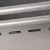 Detailaufnahme eines silbernen Metallbehälters mit Schlitzen und zwei horizontalen Stangen.