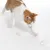 Chat roux et blanc marchant près de trois balles froissées transparentes à reflets, sur fond blanc. Les jouets sont en plastique visible.