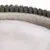 Primer plano de un tejido suave color crema con borde verde de material de felpa.