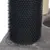 Gros plan sur une colonne recouverte de picots en plastique noir, fixée sur une base en tissu gris, partie d’un arbre à chat ou accessoire pour animaux.