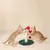 Zwei Katzen spielen mit einem Kratzbaum, der eine rote und weisse Plüschfigur sowie einen roten Ball enthält.