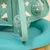 Jouet pour chat en plastique bleu avec balles ajourées et panneaux décorés d’étoiles et de sapins découpés.
