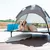 Dog lounger with sunshade roof, suitable for outdoor use. Lounger made of metal frame and fabric material, placed on terrace.