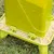Green feeder with seeds on a meadow, suitable for automatic feeding of birds or small animals.