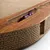 Cat toy made of corrugated cardboard with wooden surface and integrated compartment containing two purple balls.