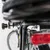 Gros plan sur le système de fixation métallique d’un porte-bagages arrière de vélo, avec feu arrière rouge visible. Matériaux : métal et plastique.