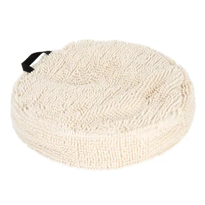 Round, cream-coloured cushion with microfibre texture and black carrying handle.
