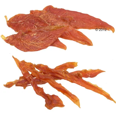 Torkade köttstrimlor och köttbitar i två olika former, liggande på vit bakgrund. Ingen synlig förpackning eller text.