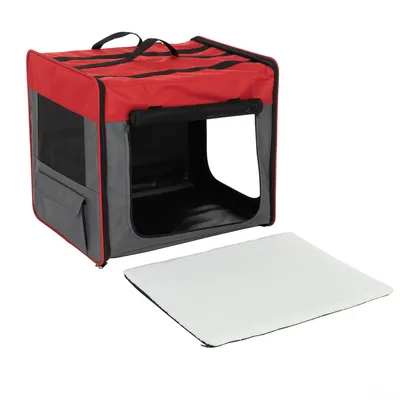 Niche de transport pliable en tissu rouge et gris avec poignée, poche latérale, ouverture frontale et tapis amovible blanc posé devant.