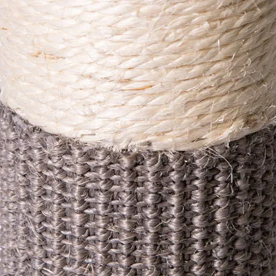 Dettaglio di un tiragraffi con corda in sisal chiara e base rivestita in tessuto intrecciato grigio.