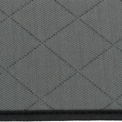 Nahaufnahme eines grauen, gesteppten Stoffmaterials mit Rautenmuster. Sichtbar ist eine schwarze Kante am unteren Rand.