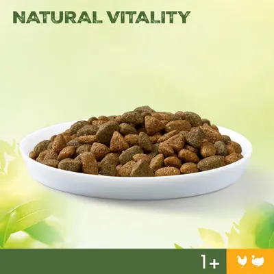 Schale mit braunem Trockenfutter, Text: NATURAL VITALITY, Symbol für Huhn und Ente, Altersangabe 1+ sichtbar.