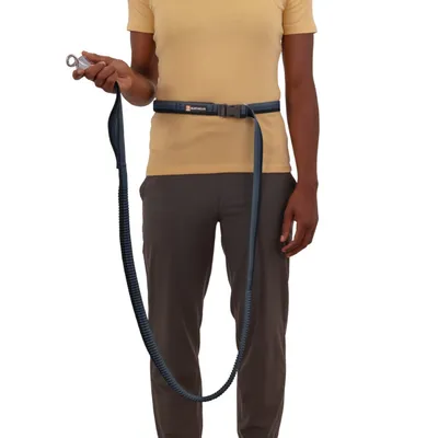 Személy kék csípőövet visel rugalmas kutyapórázzal és fém csattal a kezében. Ruffwear termék látható az övön.