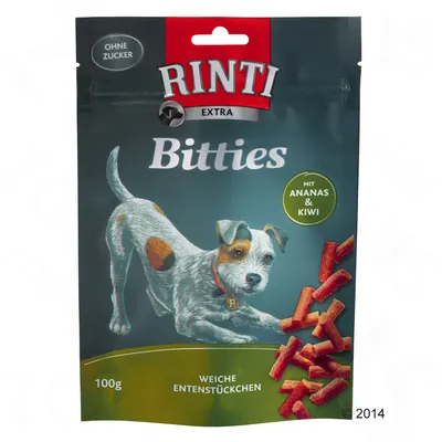 Опаковка Rinti Extra Bitties, 100 г, меки парчета патица с ананас и киви. Без захар. Видими са продуктови парченца и илюстрация на куче.