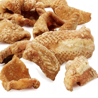 Gedroogde stukjes varkenshuid, goudbruin en knapperig, geschikt als snack voor huisdieren.