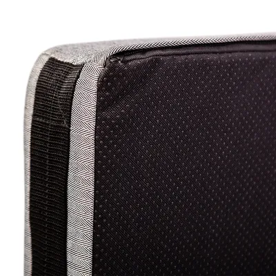 Nahaufnahme einer schwarzen, gepunkteten Stoffoberfläche mit grauem Randmuster. Detailansicht eines Produktmaterials.