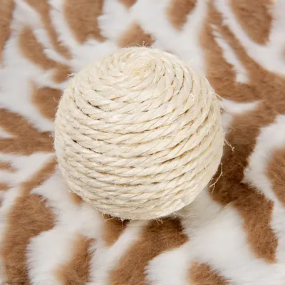 Okrugla igračka od svijetlog užeta, spiralno omotana, postavljena na smeđo-bijelu podlogu s uzorkom. Materijal: uže.