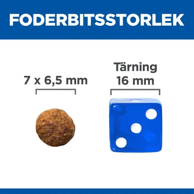 Foderbitsstorlek: foderbit 7 x 6,5 mm jämförd med tärning 16 mm. Tydlig storleksjämförelse mellan foderbit och blå spel-tärning.