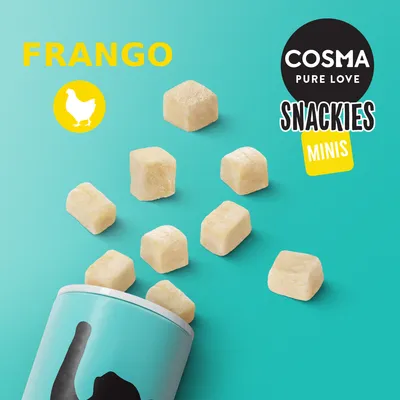 Cosma Pure Love Snackies Minis Frango. Cubos de snack a sair de uma embalagem azul. Texto visível: FRANGO, Cosma Pure Love Snackies Minis.