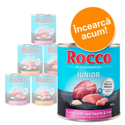 Conservă Rocco Junior 800g, text vizibil: 'Turkey with veal hearts & rice', 'SUPPORTS HEALTHY GROWTH', etichetă portocalie: 'Încearcă acum!'. Imagine cu mai multe conserve Rocco Junior.