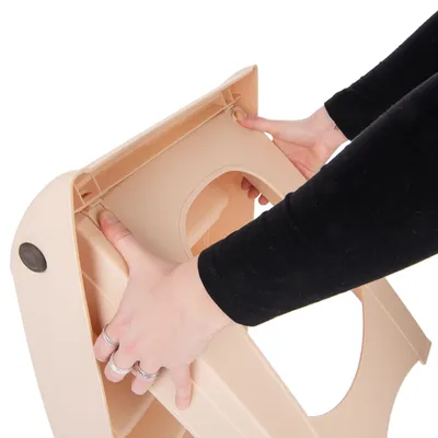 Person zeigt, wie ein beige Kunststoffteil zusammengesetzt wird. Hände drücken die Verbindungspunkte zusammen.