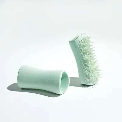 Petteezer kartáč v mátově zelené barvě s měkkými štětinami a ergonomickou rukojetí, vhodný pro péči o srst.