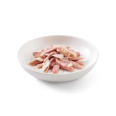 Morceaux de viande rose et blanche dans une assiette blanche, présentés sans emballage ni marque visible.