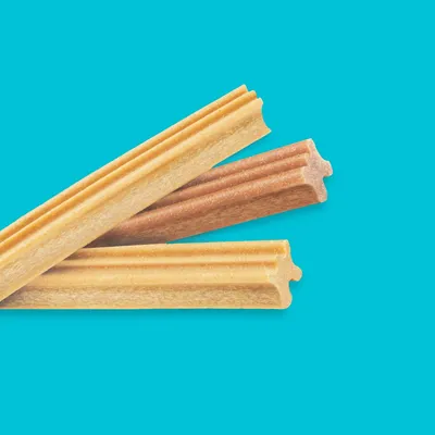 Three ridged, stick-shaped chews in different shades displayed on a blue background, showing product shape and texture.