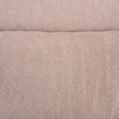 Gros plan sur une surface en tissu beige, texture tricotée visible. Aucun logo ni texte apparent.