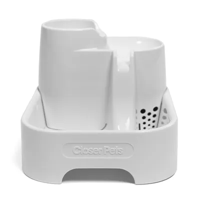 White plastic feeding or watering station with two compartments and drainage holes, Closer Pets branding visible on the front.
