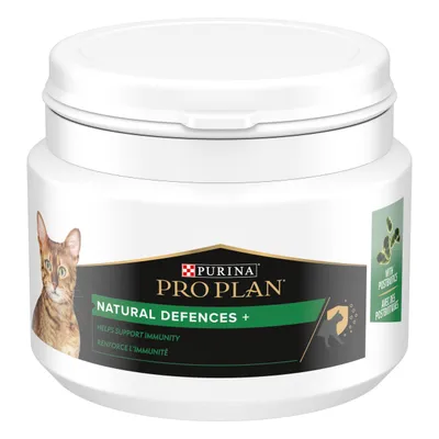 Purina Pro Plan Natural Defences+ cat supplement tub, label shows 'Helps support immunity', 'With postbiotics', image of a cat and paw print, white plastic container with screw lid.